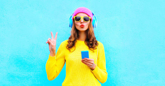 Woman in yellow sweater with colorful accessories against a light blue background