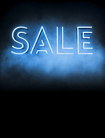 The word SALE illuminated on a dark and misty background