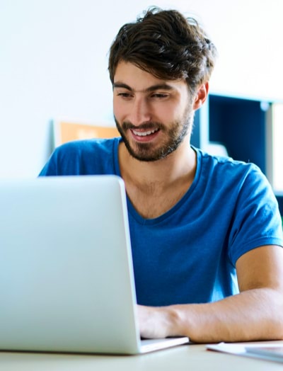 Man smiling while working on his laptop